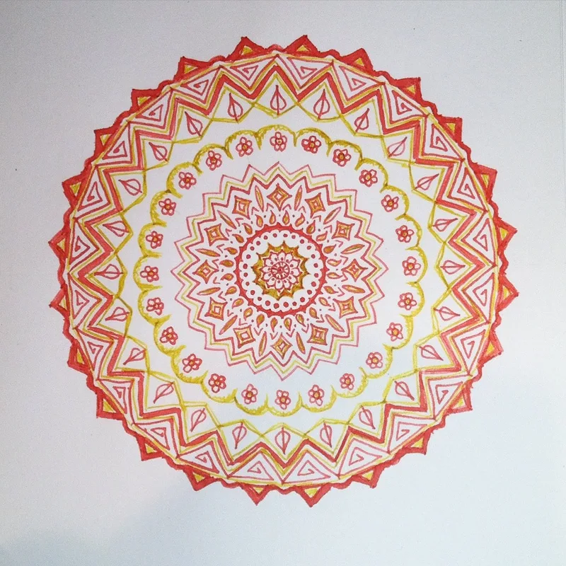 hand drawn pen and ink mandala with flowers in yellow and orange