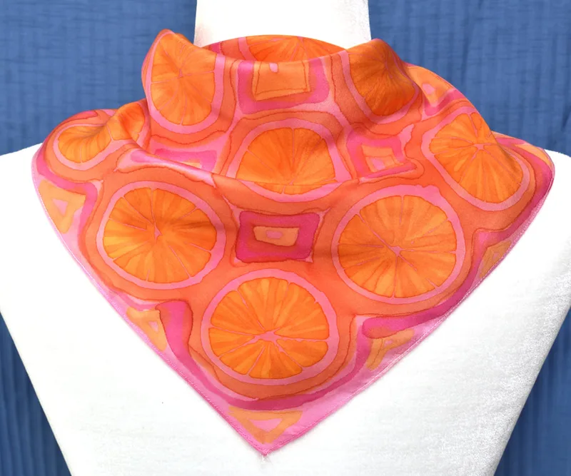 A scarf from my "Citrus" series with slices of oranges and a pink background.